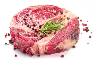 Raw beef steak with herbs and spices ready for cooking on white background.