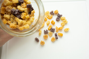 Various macarons lying on the table in the shape of pumpkins, bats, and spiders for Halloween
