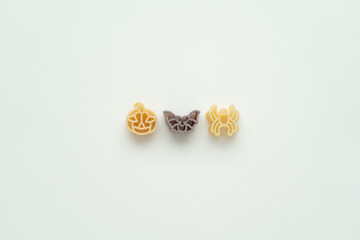 Various macarons lying on the table in the shape of pumpkins, bats, and spiders for Halloween