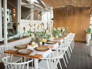 Beautiful flowers decorated on the table.Tables set for an event party or wedding reception. luxury elegant table setting dinner in a restaurant. glasses and dishes. Fancy moment fancy time.