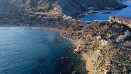 Aerial view of golden sand beach,. Ramla beach or Tuffieha beach and Il Qarraba rugged peninsula in the early morning. High quality photo