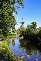Beautiful idyllic river water landscape with traditional dutch windmill in rural old countryside...