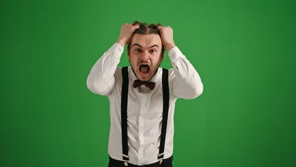 Shocked Young Man with Hands in Hair on Green Screen