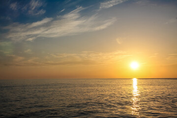 beautiful and colorful sunset, warm light and many clouds, sea waves on the sea coast