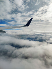 beautiful thick clouds in the sky from the height of the flight of the plane with a view of the wing with engines