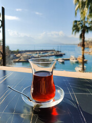 transparent cup of turkish black tea on the sea
