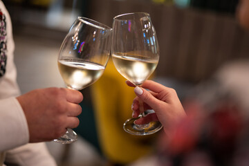 two people are holding glasses with an alcoholic drink