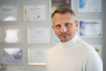 portrait of handsome adult man in a white sweater