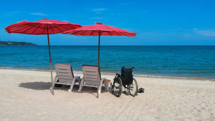 deck chairs with umbrellas  and wheelchair on the sea beach in summer