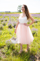 beautiful girl in a dress on a lavender field with a bouquet of flowers