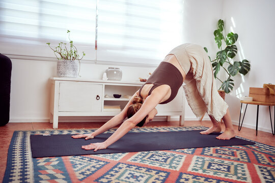 beautiful caucasian woman practicing yoga exercises, wellness at home