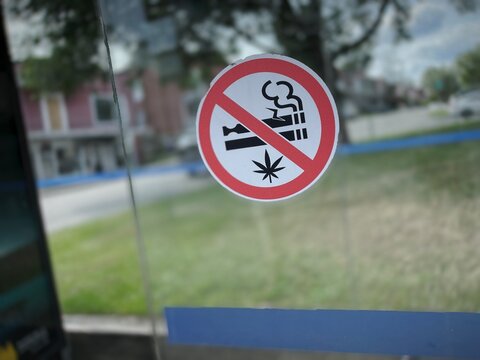 Panneau interdisant de fumer sur une porte vitr&eacute;e. Interdiction de fumer du cannabis et de vapoter.