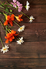 Flowers of lilies, daisies and hollyhocks on an old wooden background, summer and autumn banner for product advertising, abstract floral arrangement, rustic style, holiday card,