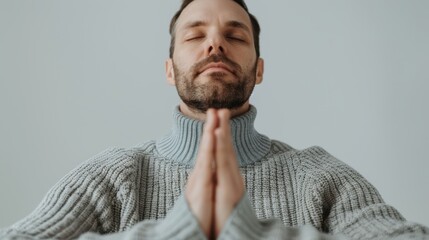 Fototapeta premium A serene man practicing mindfulness with hands in prayer position, embodying inner peace and meditation in a calm setting.