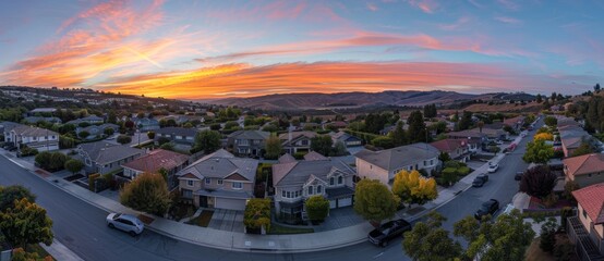 Sunset-colored aerial view of upper middle class American luxury house development in cul-de-sac neighborhood in the USA with red, yellow, and orange sunset skies in a cul-de-sac neighborhood of