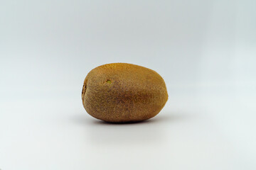 A single whole kiwi fruit is shown against a plain white background. It represents freshness and...
