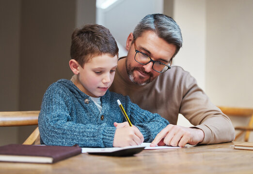 Help, homework and dad with child at desk for teaching, learning and notebook for school project. Writing, notes and father studying in home with son for support, advice and growth in kids education