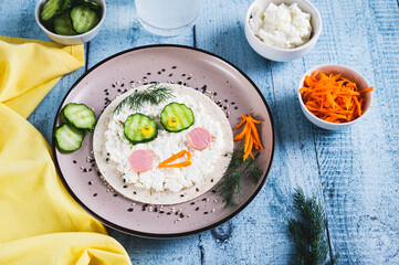 Children's lunch of tortilla, ricotta, sausages and cucumber on a plate