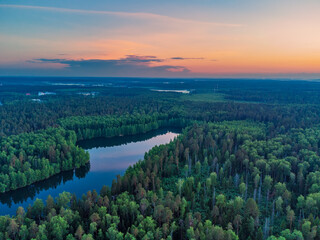 Panorama view from above of the summer landscape. Red sunset sky, fields and forests, river