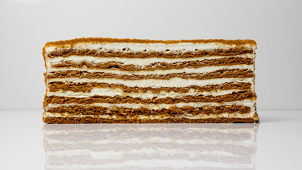 Fototapeta premium Section of a cake on a white background, cake layers, cream, pastries, dessert.