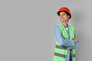 Engineer in hard hat on grey background, space for text