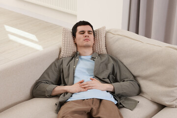 Man suffering from abdominal pain at home