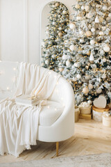 Elegant white sofa draped with a blanket and fairy lights, next to a beautifully decorated...
