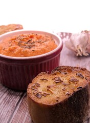 Pot of vanilla carrot crush with garlic bread on a wooden board