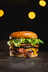 Big tasty burger on a dark background. Fast food, street food, American food
