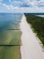 Aerial drone view of empty beach and sea side with breakwater along the Baltic Coast, Dziwnow Poland	