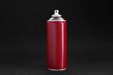 Red spray paint can on dark gray background