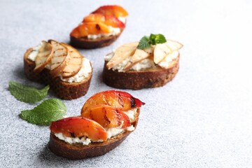 Delicious bruschettas with ricotta cheese on light grey table, closeup