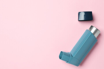 Asthma inhaler on pink background, top view. Space for text