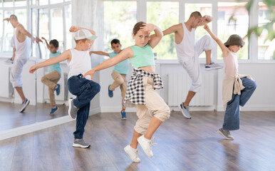 Expressive preteen girl honing hip hop dance moves in sunlit choreographic studio setting during...