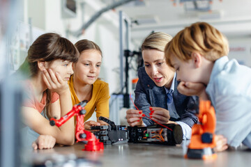 Children learning robotics in Elementary school. Young students building robot in after school...