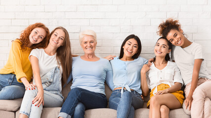 Diverse Women Of Different Age Sitting On Sofa Smiling To Camera Indoor. Support Group Concept