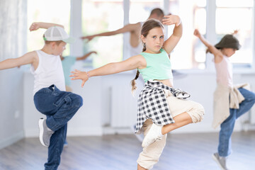 Positive girls and boys training hip hop in dance studio, dance classes for kids