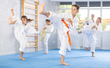 In gym, certified master coach conducts karate kata lesson with children boys girls team students...