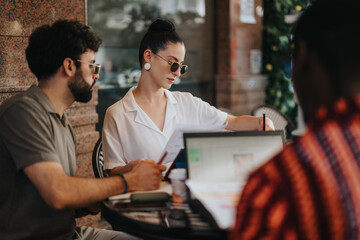 Business partners discussing a new project, planning, and analyzing statistics or strategizing in a modern coffee shop setting.