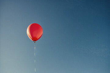 Obraz premium Ballon rouge et ciel bleu, photo minimaliste avec espace négatif pour conception personnalisée