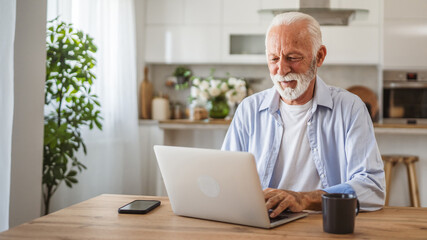 Senior man sit at kitchen drink coffee and use laptop and have fun