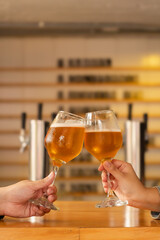 Vertical shot of a Craft Beer Toast in a modern bar - Warm and cozy atmosphere.