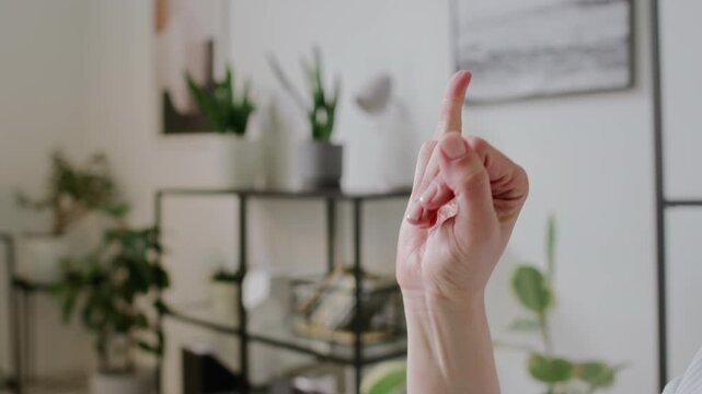 Close-up of hand of unrecognizable young woman demonstrating American sign language letters in alphabetical order in office or classroom