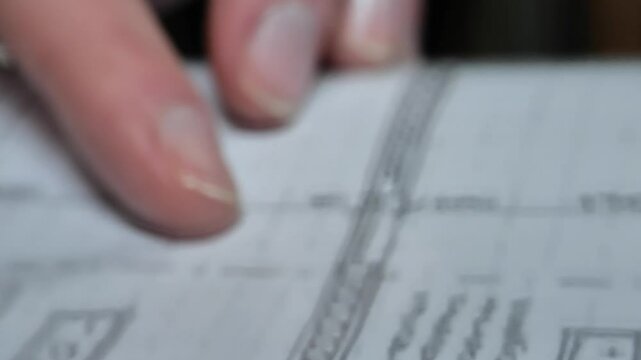 House and plot plan. Architectural drawing of the house and plot. Hand close-up examines the drawing of the site. Design documentation for the building and land plot. 4k footage