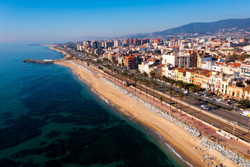 Scenic aerial view of coastal area of Spanish city of Vilassar de Mar overlooking brownish roofs of...