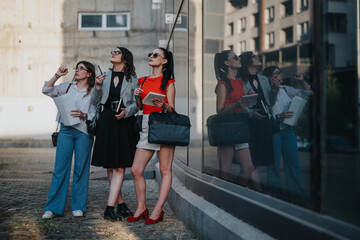 Obraz premium Three confident businesswomen collaborate outdoors, analyzing blueprints and planning a project. Concept of teamwork, leadership, and modern businesswomen.