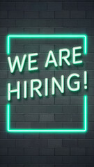 Obraz premium We Are Hiring Neon Green Sign Framed in Neon Light on Dark Brick Wall - Perfect for Modern HR Recruitment Campaigns