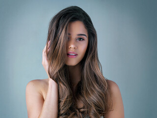 Portrait, serious and woman with hair care in studio for salon treatment, confidence or...