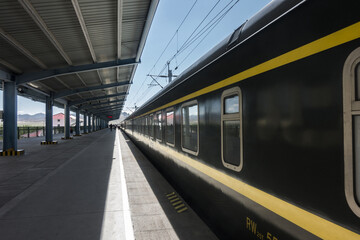 Chengdu, Sichuan, China - August 9, 2019: A Qinghai–Tibet train with cabin windows is parked on railroad besides platform at Chengdu Station
