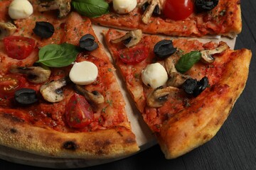 Tasty pizza on black wooden table, closeup